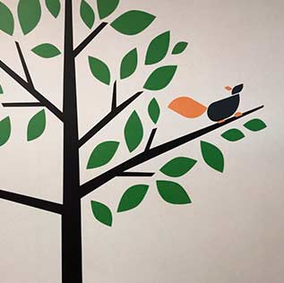 Vinilo de un arbol de varios colores pegado en pared